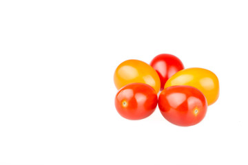 Yellow and red cherry tomatoes on white background