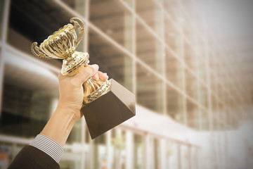holding trophy awards after successful