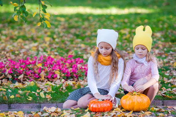 Wall Mural - Adorable little girls with pumpkins outdoors at beautiful autumn