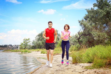 Wall Mural - Young people jogging on beach