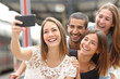 Group of four friends taking selfie with a smart phone