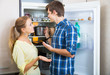 © JackF - man and woman standing near fridge in kitchen