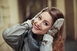 Happy young woman in mittens smiling and looking at camera. Close up

