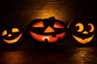 Funny Jack o lanterns Halloween pumpkins. Dark wooden background. Without light