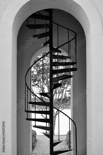 Fototapeta na wymiar Black and white photo of tall metal stairs in a clock tower stairwell