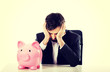 © Piotr Marcinski - Businessman with piggybank by a desk.