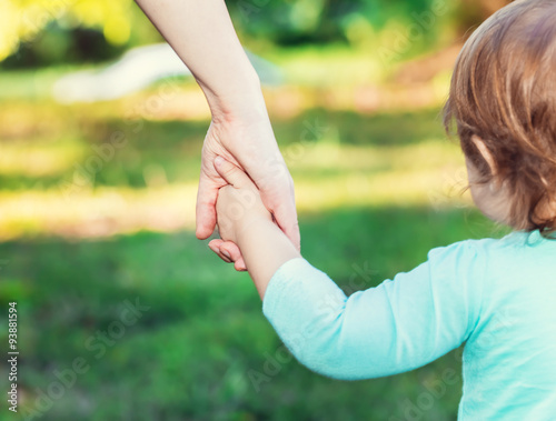 Fotografering Toddler girl holding hands with her mother