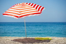 Striped Beach Umbrella On The Beach.

