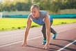 © naataali - Athletic man standing in  posture ready to run on a treadmill