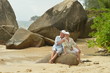© aletia2011 - Happy elderly couple sitting on a large rock on the beach