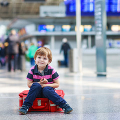 Wall Mural - Little boy going on vacations trip with suitcase at airport