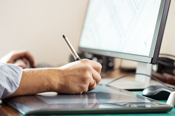 Leinwandbilder - Graphic designer using digital tablet and computer in office or