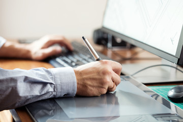 Leinwandbilder - Graphic designer using digital tablet and computer in office or