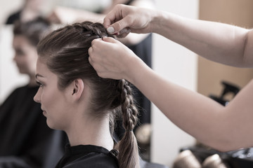 Wall Mural - Braiding young woman's hair