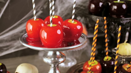 Wall Mural - Table with colored candy apples for Halloween party