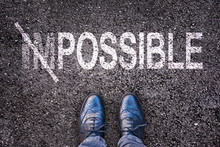 Changing The Word Impossible On Possible On An Asphalt Road With Feet