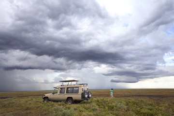 Wall Mural - Safari car in the african savanna before thunderstorm