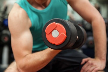 Wall Mural - Man lifting dumbbell weight while sitting