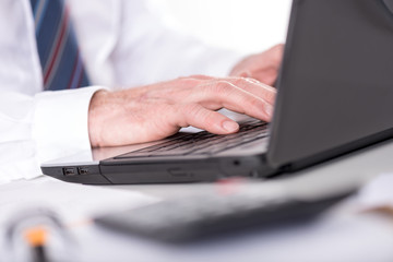 businessman typing on laptop computer
