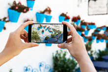 Female Hands Taking A Picture With Mobile Phone In A White Village In Andalusia, Spain.