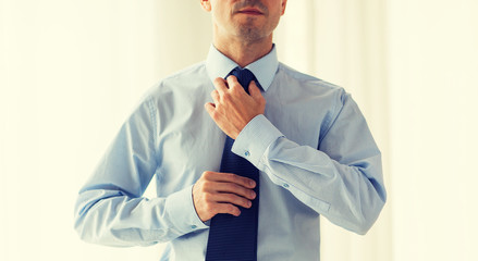 Sticker - close up of man in shirt adjusting tie on neck