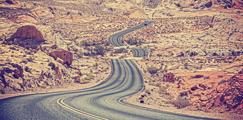 Vintage toned curved desert highway, travel adventure concept.