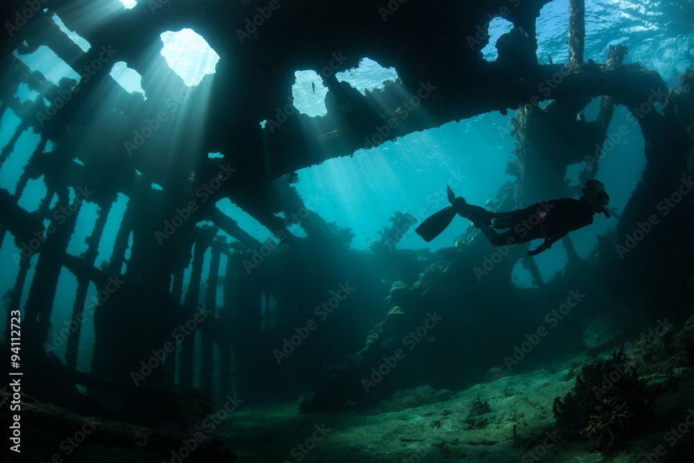 Free Diver Swimming Through Shipwreck - obrazy, fototapety, plakaty 