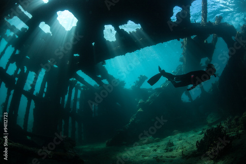 Fotomural Free Diver Swimming Through Shipwreck