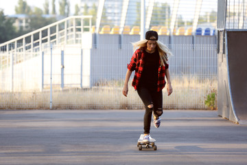 Young woman with skating board on the road