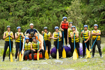 A group of kids building a raft together for an outdoor adventure on the rapids, showcasing teamwork and sportsmanship in the water.