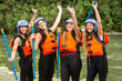 A group of teenage rafters in Ecuador's lush jungle, navigating through white water rapids as they embark on an adrenaline-pumping adventure.