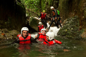 Wall Mural - Experience the thrill of canyoning in the Ecuadorian rainforest with a dynamic group of adventurous young individuals.