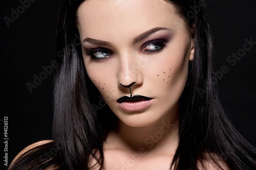 Fotografie, Obraz Beautiful young woman dressed as a cat. Make up cat. Halloween