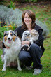 Dog breeder with Australian Shepherd adult female dog and her puppies in arms