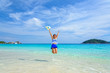 © yongkiet - Tourist girl in a blue white striped swimsuit jumping with happy on the beautiful beach and sea during summer at Koh Miang Island, Mu Ko Similan National Park, Phang Nga province, Thailand