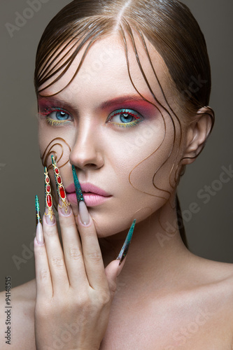 Obraz w ramie Beautiful girl with bright fashion make-up, creative hairstyle, long nails. Design manicure. Beauty face.