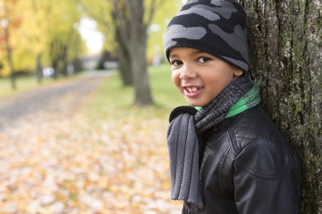 Wall Mural - cute boy with autumn leaves in the park