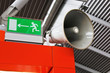 Emergency exit sign and public address system megaphone at the airport.