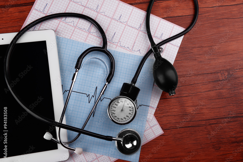 Blood pressure meter, digital tablet and stethoscope, on wooden background