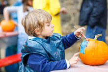 Little Kid Boy Painting With Colors On Pumpkin