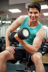 Wall Mural - Smiling man lifting dumbbell weight