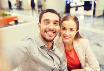 Wall Mural - happy couple taking selfie in mall or office