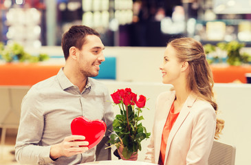 Poster - happy couple with present and flowers in mall