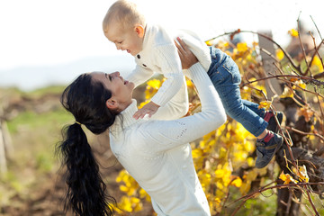 Happy mother with her son in a autumn nature