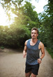 © Flamingo Images - Jogger running through a wooded park