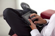 © COSPV - Happy young businessman holding and touching a digital tablet and sitting on couch