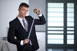 © COSPV - Young businessman in a suit holding a tape measure and looking t