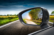 strada di campagna riflessa nello specchio retrovisore