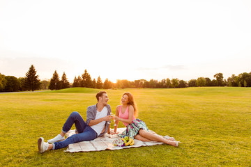 Canvas Print - Cheers! Young man and woman at picnic