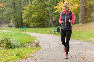 Girl walking in park with headphones